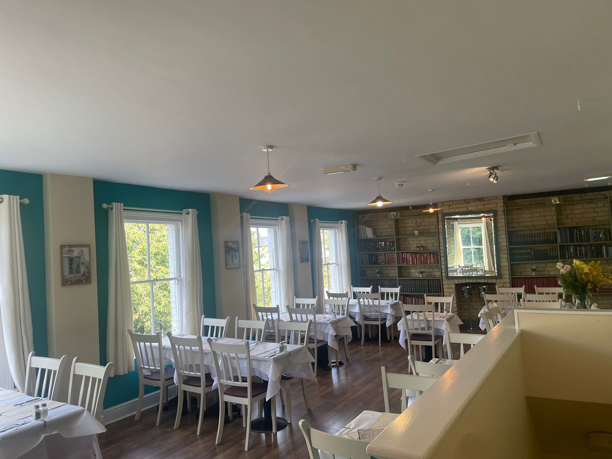 Upstairs restaurant with white chairs and tables at Soleá Bistro